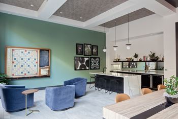 a living room with blue chairs and a table and a bar